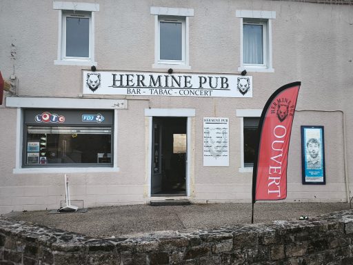 Façade du Hermine Pub avec enseigne et drapeau, situé sur une rue.